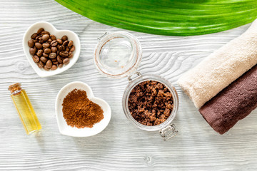 Organic coffee soap, coffee grains, oil and towel on wooden background top view