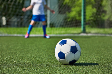 Obraz na płótnie Canvas Soccer ball on grass and football boy at gate keeper