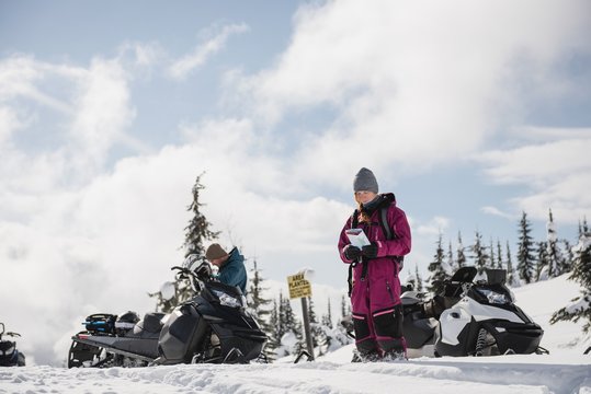 Woman looking at map in snowy alps