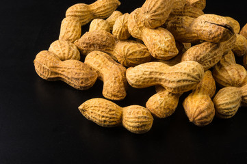 Peanuts in shell on dark background, close up