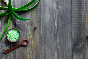 Skin care. Aloe vera leafs and spa salt on wooden background top view copyspace