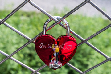 Verliebtes Paar in H0-Größe küsst sich auf Liebesschloss