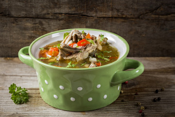 Homemade chicken soup in a green bowl