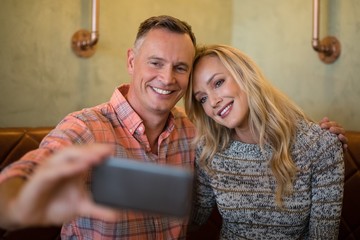 Couple taking selfie on mobile phone in restaurant