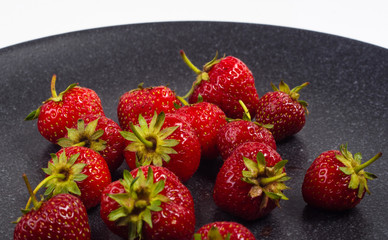 fresh ripe strawberries on black ceramic plate