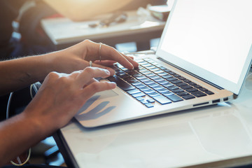 working with laptop,using laptop computer,working on desk,blank screen laptop mock up,selective focus vintage tone and sun flare effect