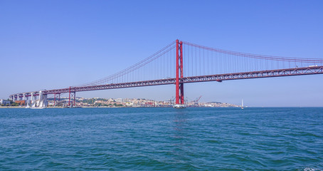 Fototapeta na wymiar Famous 25th April Bridge over River Tajo in Lisbon aka Salazar Bridge - LISBON - PORTUGAL - JUNE 17, 2017