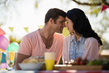 Smiling couple embracing head to head