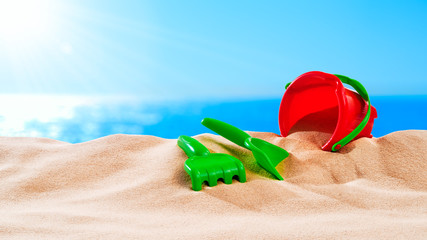 On the Beach - sand toys on a sand dune in front of beautiful azure sea on a sunny day
