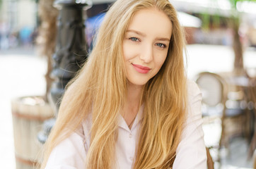 Outdoor summer portrait of young attractive lady in a cafe