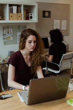 Female executive working on laptop at desk