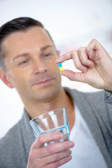 Man holding tablet and glass of water