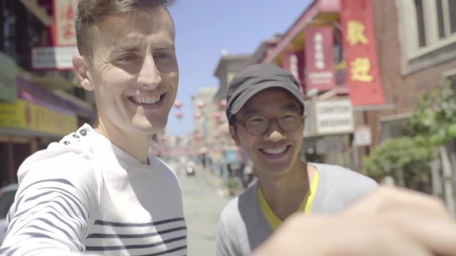 Cute Gay Couple Enjoy A Visit To Chinatown, San Francisco, They Run Into The Street To Take A Selfie With The Red Chinese Lanterns In The Background 