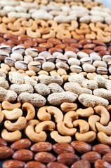 Different kind of nuts lie strips. Cashew almonds peanuts pistachios .
