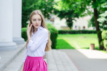 Obraz premium Outdoor summer portrait of a young attractive lady walking in the park