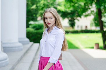 Obraz premium Outdoor summer portrait of a young attractive lady walking in the park