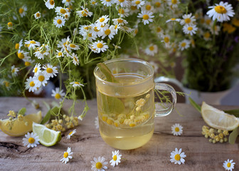 Cup of aromatic tea from fresh herbs - chamomile,linden and lemons.
