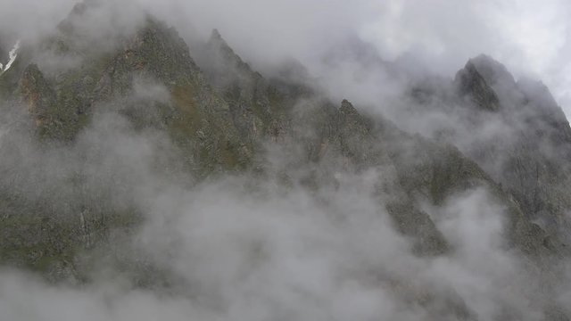 Clouds growing under sharp rock