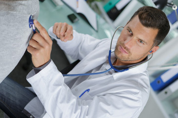 doctor holding stethoscope in his hand and doing auscultation