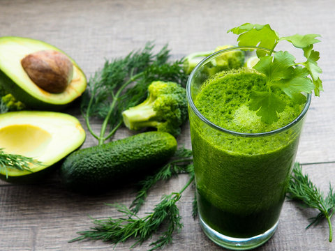 Healthy green vegetable juice on wooden table