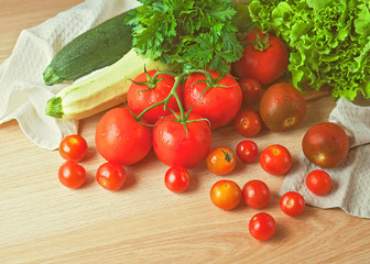 Tomatoes, parsley, zucchini and lettuce on a wooden table. 