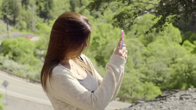 Hispanic Teen Documents Road Trip, Takes Photos Of Her Two Friends, On Top Of Mountain Above Road 