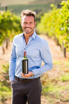 Portrait Of Handsome Man Holding Wine Bottle