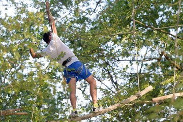 boyclimbing on the rope in the forest