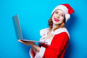 Santa Claus girl in red clothes with laptop computer