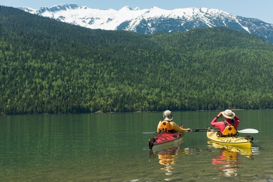 Couple kayaking in lake by mountain