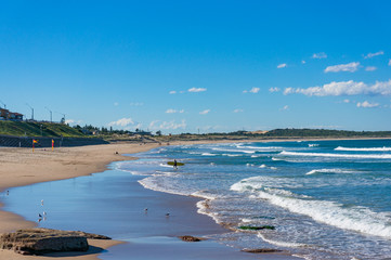 Cronulla beach with unrecognizable surfers