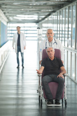 doctor looking at senior patient on wheel chair