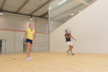 couple playing tennis game indoori in tennis court