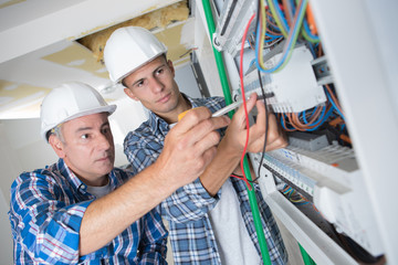 manager and apprentice working with cables