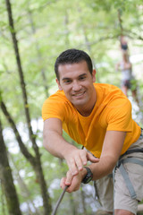 happy man at the extreme rope park with carabiners