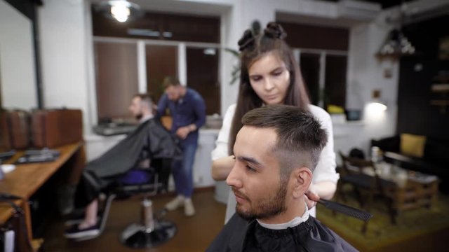 Woman and man making classic stylish hair to male customers in salon