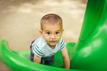 Fototapeta na wymiar happy little boy climbing on children playground