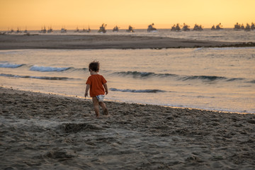 Baby boy at beautiful sunset in Mancora Beach - Mancora, Peru