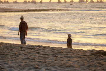 Father and son walking at Beautiful sunset in Mancora Beach - Mancora, Peru