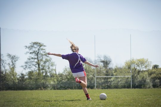 Rear view of young woman playing soccer