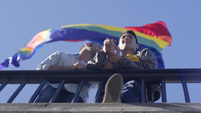 Low angle view of couple standing under rainbow flag