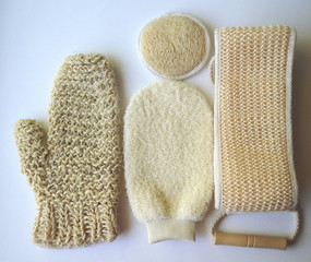 Top close up view of a set of body massage brushes for dry brushing, exfoliation and lymph drainage with a red rose on white
