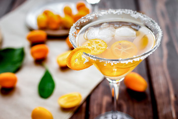 cocktail with kumquat on wooden background