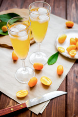 cocktail with kumquat on wooden background