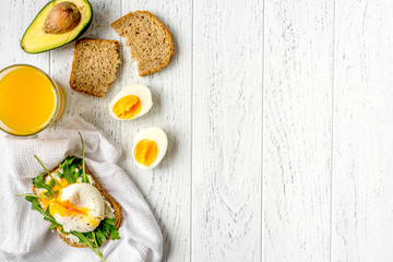 Fototapeta na wymiar sandwich with poached eggs on wooden background top view mockup