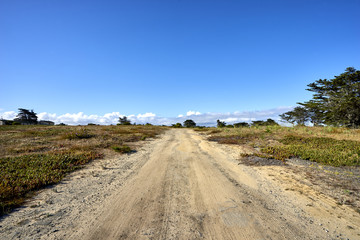 sand road towards deserted buildings on military installation
