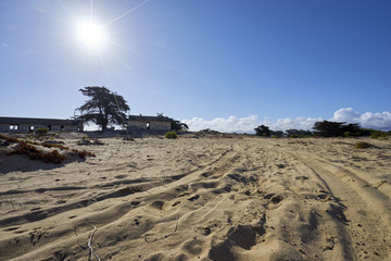 Obraz premium tire tracks through the sand leading to deserted military base