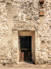 Old weathered wooden door in a stone wall