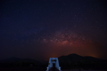 Fototapeta na wymiar Milky way over white bridge at lamphun in Thailand. Selective focus on the Milky Way