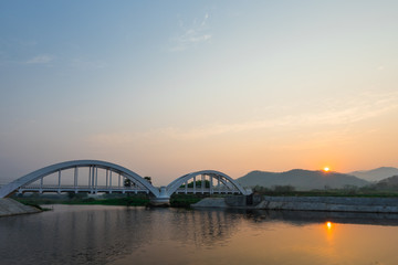 The white bridge backdrop orange sky at the morning in Lamphun. Thailand